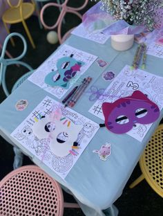 a blue table topped with lots of paper cut outs and masks on top of it