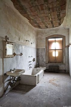 an old bathroom with two sinks and a bathtub in the middle of the room