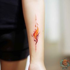 a woman's arm with a small fire tattoo on the left side of her arm