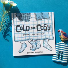 a card with the words cold but cosy on it next to a bird figurine