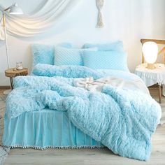 a bed with blue comforters and pillows in a room