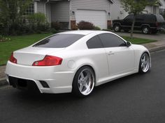 a white sports car parked in front of a house