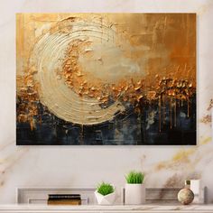 an abstract painting in gold and black on a white wall above a fireplace mantel