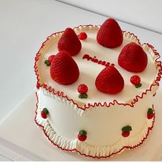 a white cake topped with strawberries on top of a table