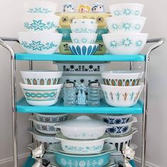 a stack of bowls sitting on top of a blue shelf next to a white wall