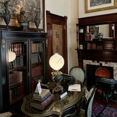 a living room filled with furniture and a fire place next to a bookshelf