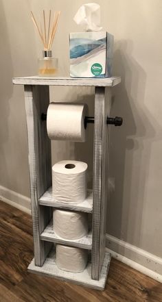 a shelf with two rolls of toilet paper on it and a box of tissues next to it