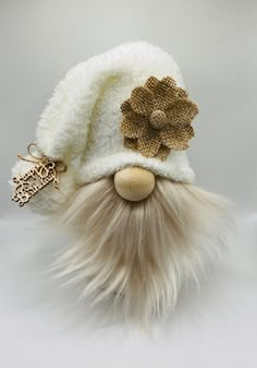 a white hat with long hair and a flower on the top is sitting next to a keychain