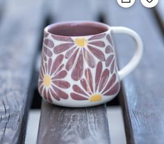 a coffee cup sitting on top of a wooden bench