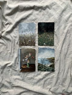 four different paintings are displayed on a white t - shirt that is laying on a bed