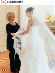 the bride is getting ready to walk down the aisle in her wedding dress and veil