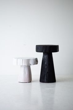 two black and white stools sitting next to each other on top of a table