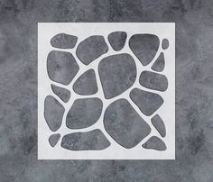 a white square with some black rocks on it's side in the middle of a cement floor