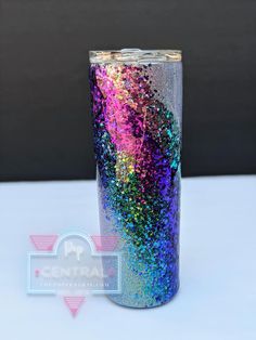 a purple and blue glitter tumbler sitting on top of a table