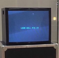 a small tv sitting on top of a metal stand in front of a wall with the words lone hill fix it