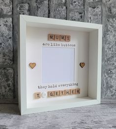 a white frame with scrabbles and words in the shape of hearts on it