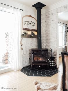 a living room with a wood stove in the center and white brick wall behind it