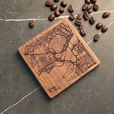 a wooden coaster with a city map on it and coffee beans scattered around the coaster