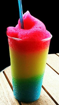 a colorful drink sitting on top of a wooden table