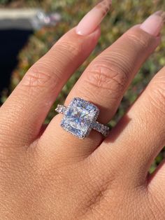 a woman's hand with an engagement ring on it