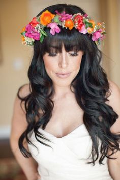 a woman with long black hair and flowers in her hair is taking a selfie