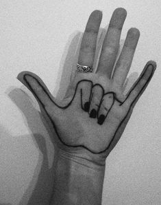 a person's hand with black and white ink on it, holding up the middle finger