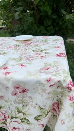 a white plate sitting on top of a table covered in pink and green floral fabric