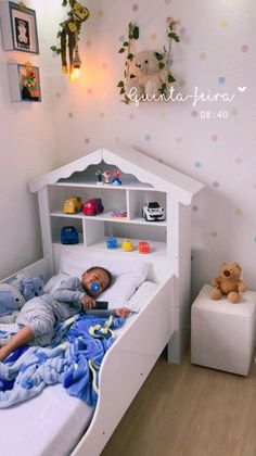 a little boy laying in his bed with toys on the nightstands next to him