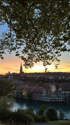 the sun is setting over a city and river