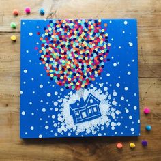 an art project made out of colored confetti on blue paper with a house in the air