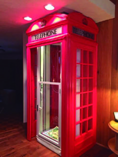 a red phone booth sitting on top of a hard wood floor