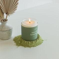 a candle that is sitting next to some green stuff