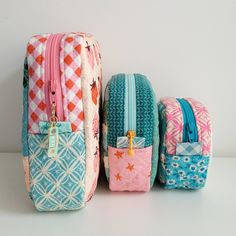 three pieces of colorful luggage sitting next to each other on a white surface with no one around them