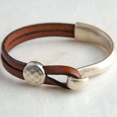 The beauty is in the simplicity. High quality components and expert craftmanship combine to make this popular - and gorgeous - leather wrap cuff bracelet for women and men a "must have" jewelry staple. Great for gift-giving. It's wearability and style suits both casual and dressy occasions.  This leather cuff features genuine leather, a sterling silver plated half hook clasp, and a hammered coin slider bead. This is my original design, first sold here on Etsy in 2017, and each item is handmade s Bracelet For Boys, Asymmetrical Shapes, Wrap Armband, Jeweled Shoes, Bracelets Boho, Handmade Leather Bracelets, Rock Artists, Cross Bones, Red Moon