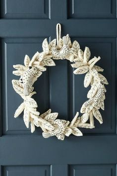 a wreath is hanging on the front door with leaves and birds painted on it's side