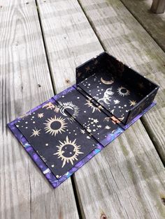 an open box sitting on top of a wooden table covered in stars and moon designs