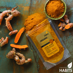 tumerical powder and ginger root on a wooden table