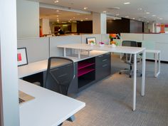 an empty office with desks and chairs in the middle of it, along with other cubicles