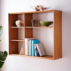 a wooden shelf with books and bowls on it