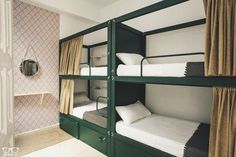 bunk beds are lined up against the wall in this small room with curtains and drapes