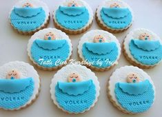 cookies decorated with blue icing and white frosting are arranged in the shape of baby's bib