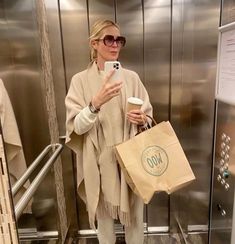 a woman is taking a selfie with her cell phone while holding a starbucks bag