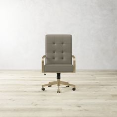 an office chair sitting on top of a hard wood floor next to a white wall