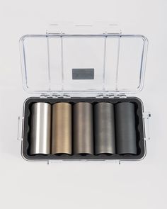 six rolls of metallic colored paper in a clear case