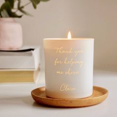 a white candle sitting on top of a wooden plate