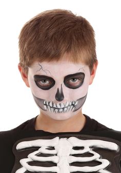 a young boy with his face painted white and black, is wearing a skeleton costume