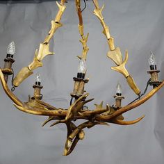 a chandelier made out of antlers with lights on them