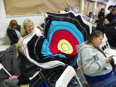 two women sitting in chairs with blankets on their backs and one woman holding a crocheted blanket