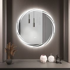 a bathroom with a round mirror on the wall next to a vase and two bottles