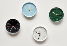 three clocks with different colors and numbers on the faces are arranged in order to show time